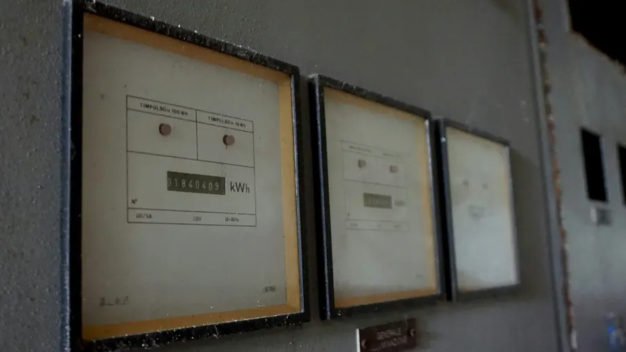 Analoge Stromzähler an einer grauen Wand