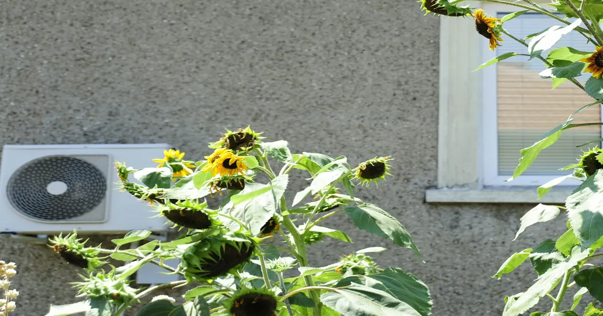 Außengerät einer Luft-Wärmepumpe an der Fassade eines Wohnhauses